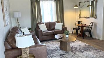A modern living room with a brown leather sofa, a round coffee table, and a floor lamp.