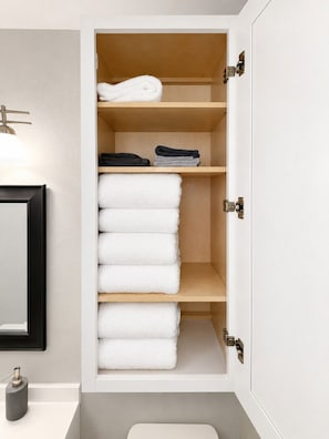 A bathroom with a white sink, a mirror, and a towel storage cabinet with multiple shelves. - Arlington Apartment - 3/4 Mile from AT&T Stadium (Arlington)