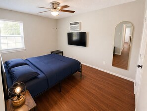 A bedroom with a bed, a ceiling fan, a TV, and a mirror. - Arlington Apartment - 3/4 Mile from AT&T Stadium (Arlington)