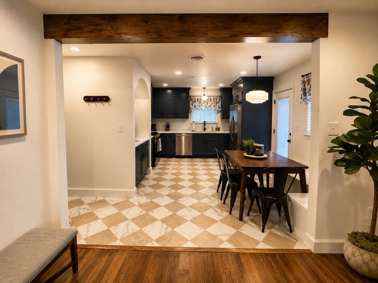 A modern kitchen with a checkered floor, a dining area with chairs, and a bench.