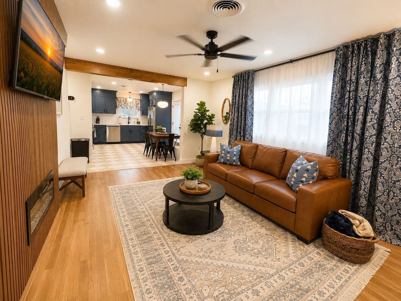 A living room with a brown leather sofa, a round coffee table, and a patterned rug.