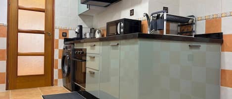 A kitchen with a built-in oven, microwave, and coffee maker.