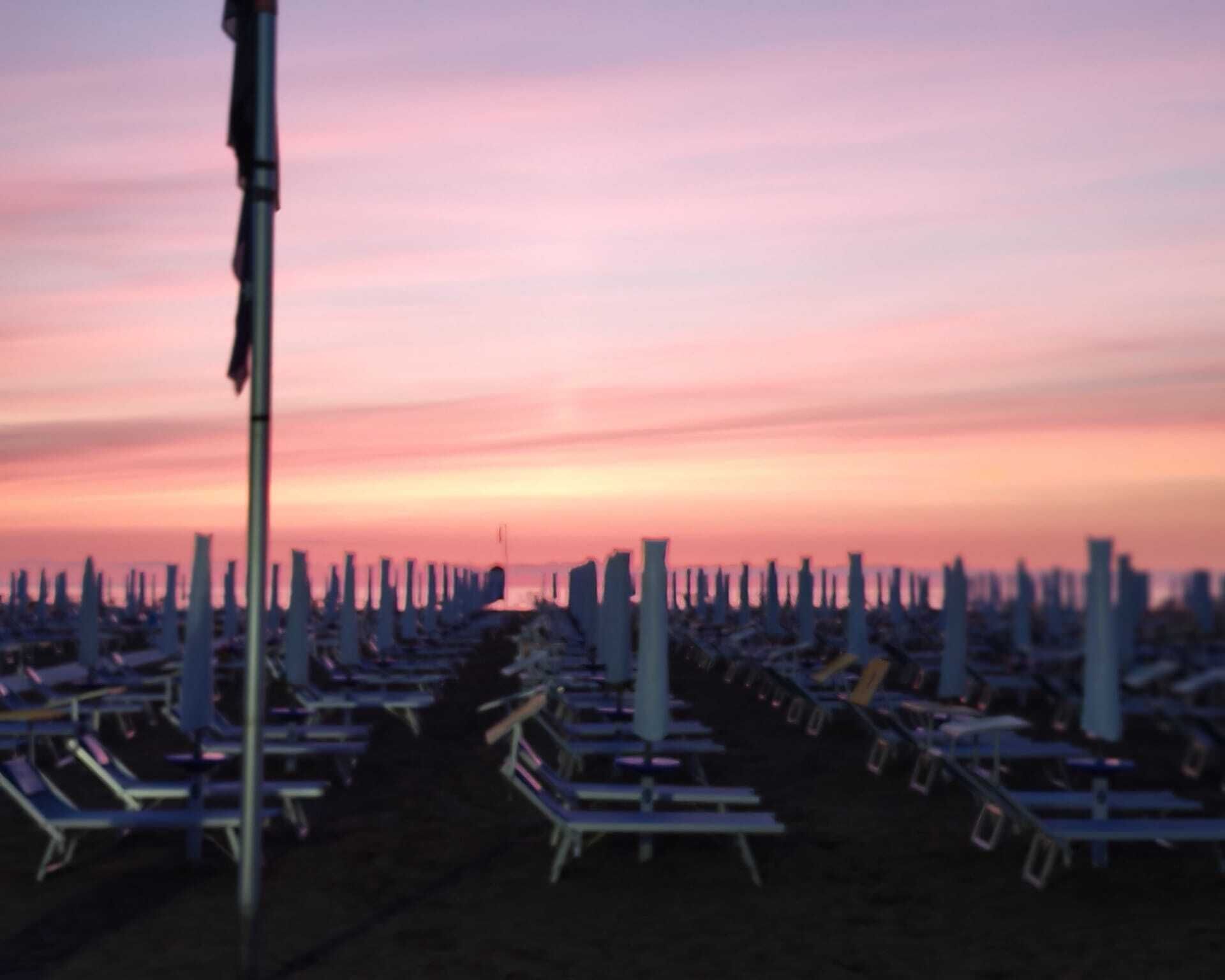 Une rangée de chaises longues alignées sur une plage.