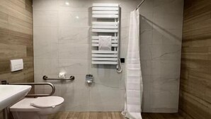 Une salle de bain moderne équipée d’une douche, de toilettes et d’un lavabo.