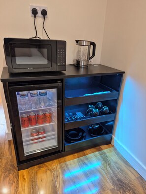 A compact kitchenette with a microwave, a coffee maker, and a mini-fridge stocked with beverages. - New apartment in prescot own access (Prescot)