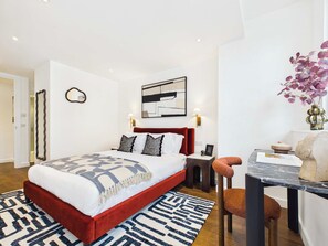 A modern hotel room with a large bed, a desk, and a chair. - Chic Baker Street Apartment with Balcony (Greater London)