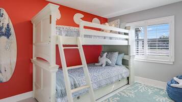 A bunk bed with a ladder, a surfboard, and a window with blinds.