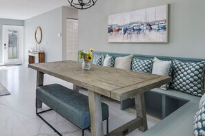 Ein Essbereich mit Holztisch, Sitzbänken und einem Wandbild.