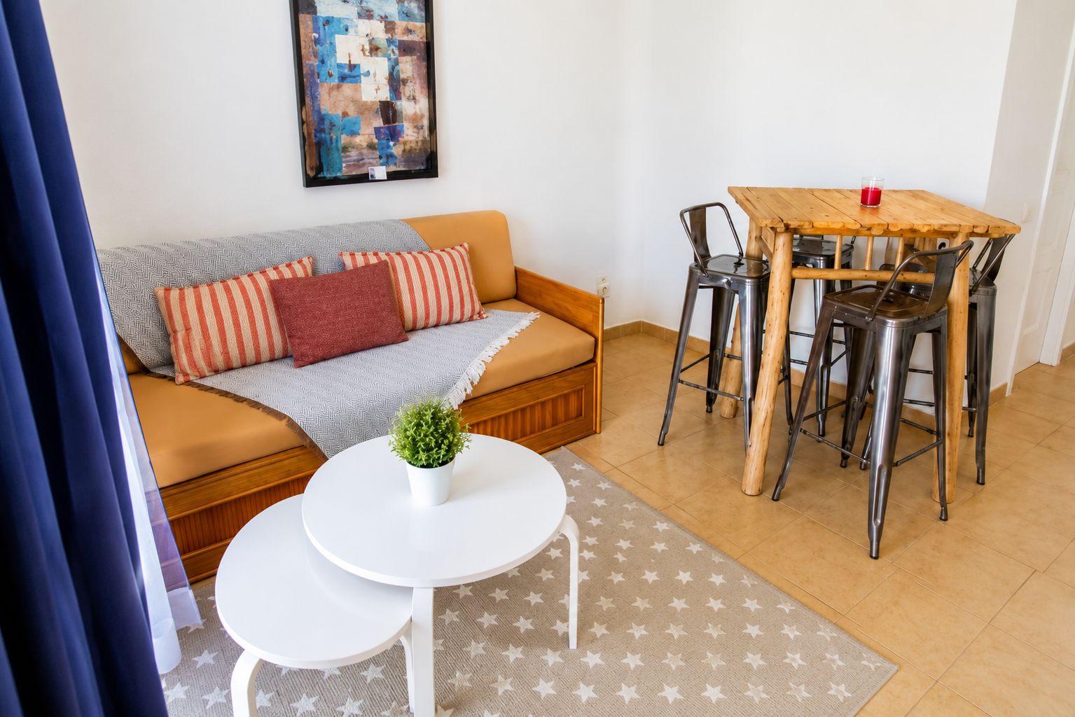 Et møbleret opholdsstue med sofa, spisebord og stole.
