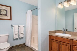 Ein Badezimmer mit Toilette, Waschbecken, Dusche und Handtuchhalter.