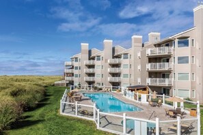 Ein mehrstöckiges Hotel mit Schwimmbad, Außenbereich und Blick auf den Strand.