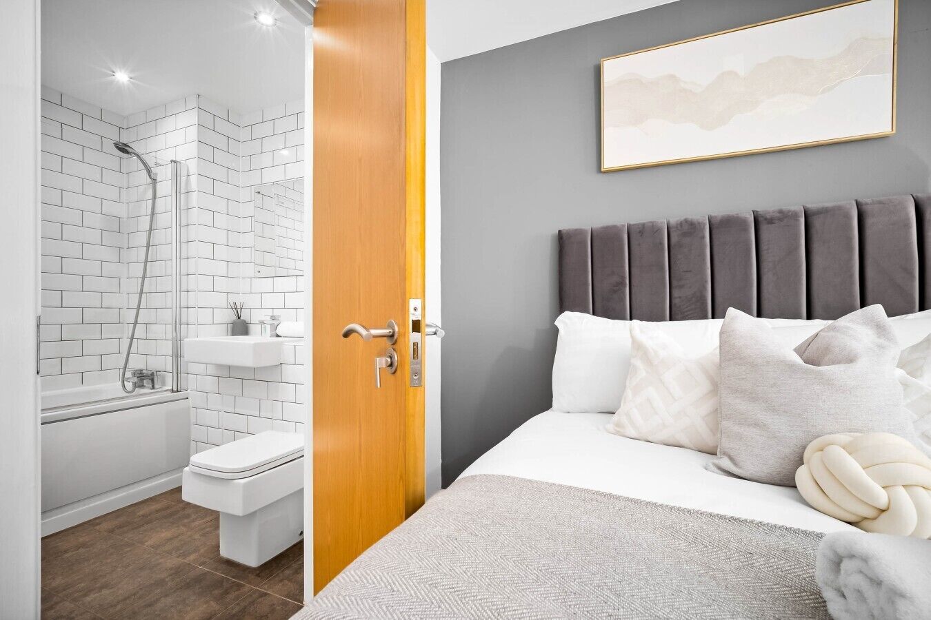 Een moderne badkamer met douche, toilet en wastafel.