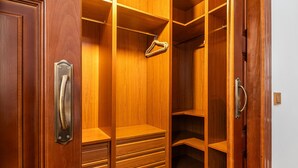 Een houten inloopkast met meerdere planken en lades.