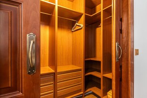 Ein begehbarer Kleiderschrank aus Holz mit mehreren Regalen und Schubladen.