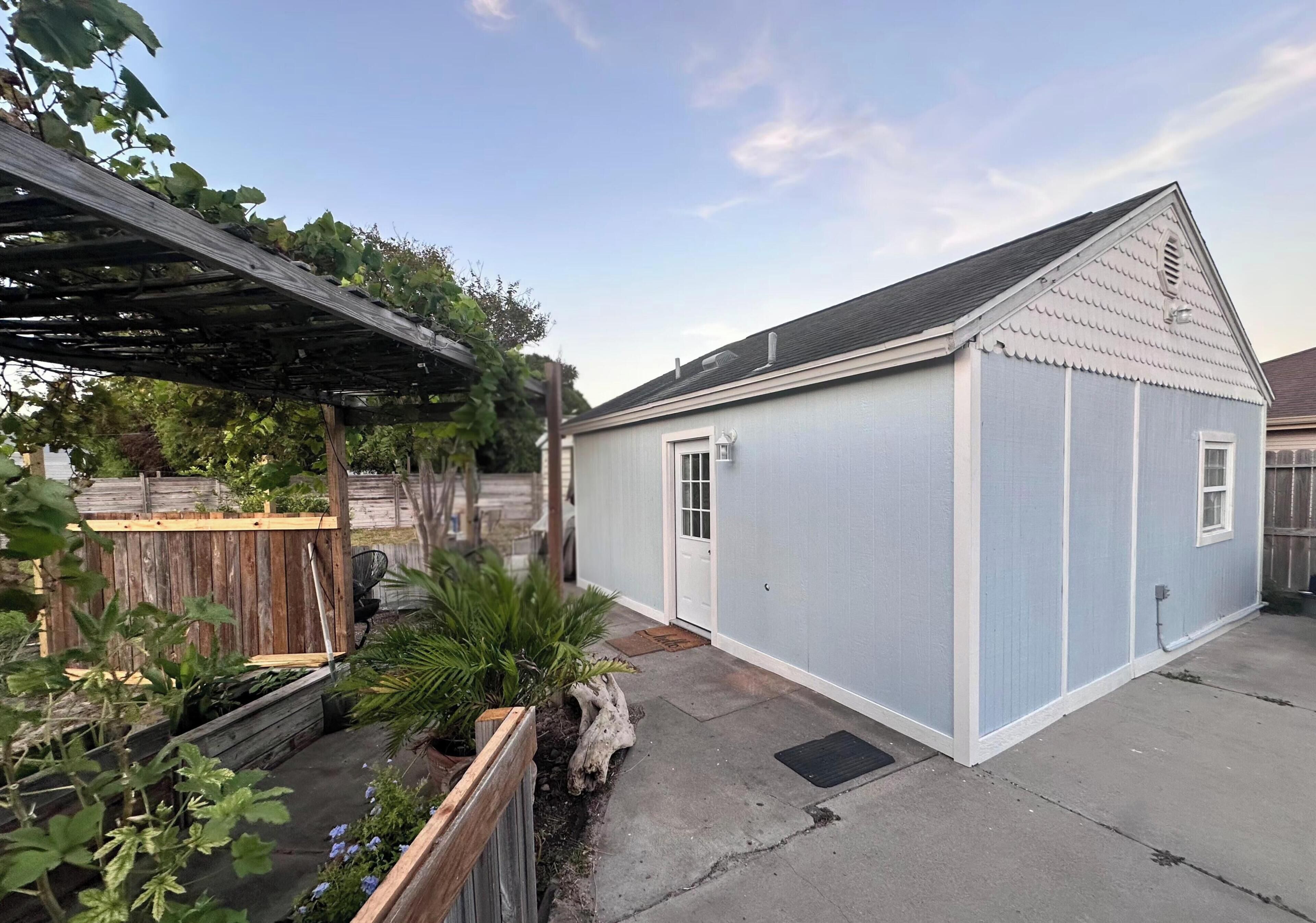 A small, single-story building with a gabled roof, a front door, and a small porch area.