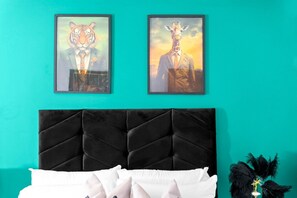 A room with a teal wall, a black upholstered headboard, and two framed animal portraits. - Luxe Two Bed Apartment - City Centre - Balcony & Parking (Birmingham)