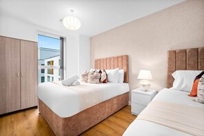 A modern hotel room with a large bed, a bedside table, a wardrobe, and a view of the city. - Stylish Apartment * Sleep 4 * Parking * Netflix (West Midlands)