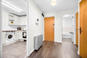 Eine moderne Küche mit Waschmaschine, Mikrowelle und Backofen.