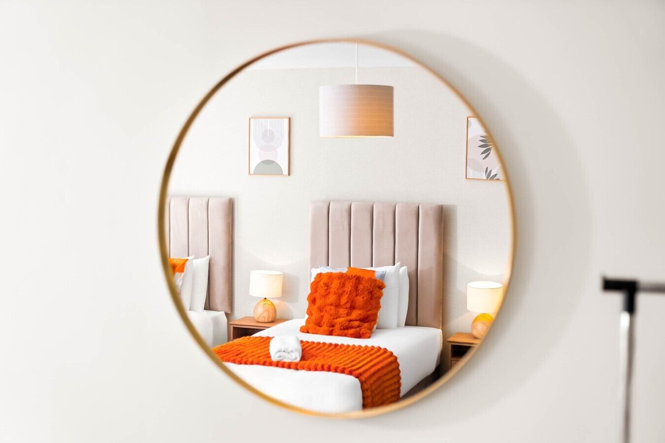 Een hotelkamer met een bed, nachtkastjes, een lamp en een spiegel.