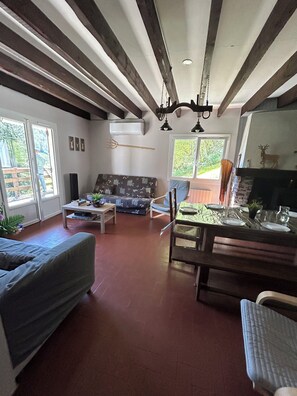 A living room with a sofa, a dining table set for two, and a fireplace.