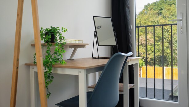 A workspace with a desk, chair, easel, and potted plant. - Spacious 5Bed House in Ruislip Sleeps 10 (Ruislip)