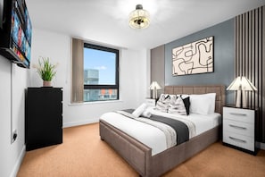 Ein modernes Hotelzimmer mit einem großen Bett, einem Flachbildfernseher, einer Zimmerpflanze, einem Fenster mit Blick und einem Wandbild.