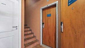 A private room with a white door, a wooden door with a sign, and a staircase. - Baia da Luz Resort | 2BR with Pool by LovelyStay (Praia da Luz)