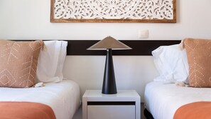 A hotel room with two beds, a nightstand, a lamp, and a decorative wall piece. - Baia da Luz Resort | 2BR with Pool by LovelyStay (Praia da Luz)