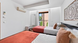 Ein Hotelzimmer mit zwei Betten, einem Balkon und einer dekorativen Wandverkleidung.