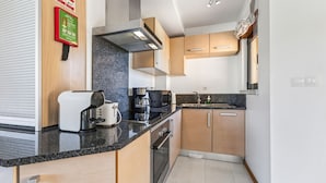 A compact kitchen with a built-in oven, a coffee maker, and a toaster. - Baia da Luz Resort | 2BR with Pool by LovelyStay (Praia da Luz)