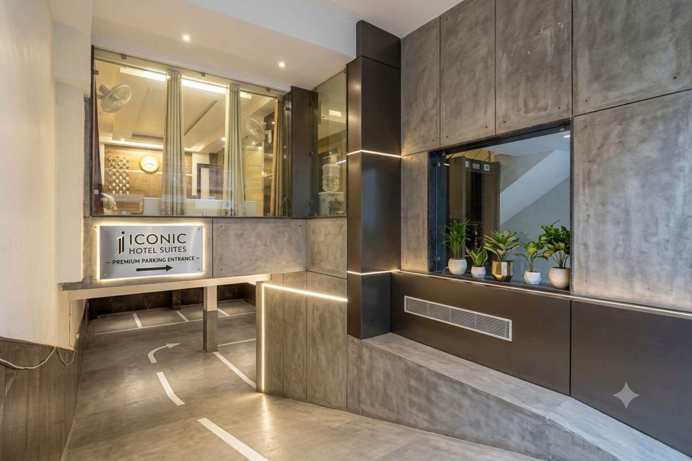Een hotel ingang met een bordje voor 'Iconic Hotel Suites' en een toegangspoort voor premium parkeerplaatsen.