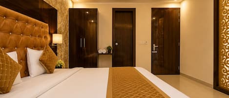 Une chambre d’hôtel moderne avec un grand lit, une armoire en bois foncé et un panneau décoratif mural.