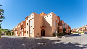 A multi-story hotel with a consistent architectural style, featuring balconies and a central entrance. - Baia da Luz Resort | 1BR with Pool by LovelyStay (Praia da Luz)