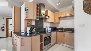 A modern kitchen with a built-in oven, a coffee maker, and a toaster. - Baia da Luz Resort | 1BR with Pool by LovelyStay (Praia da Luz)