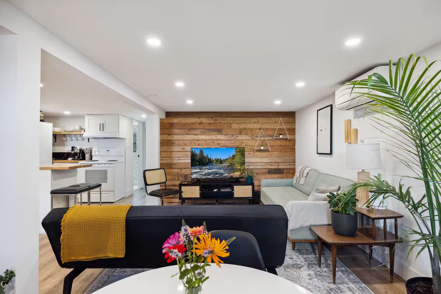 A modern living room with a television, sofa, and dining area.