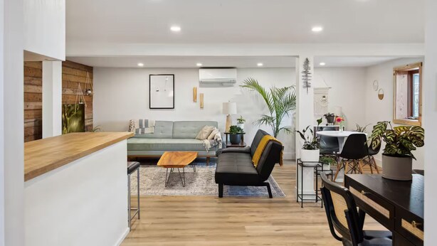 Un soggiorno moderno con un divano, un tavolino da caffè e una zona pranzo con sedie e un tavolo.
