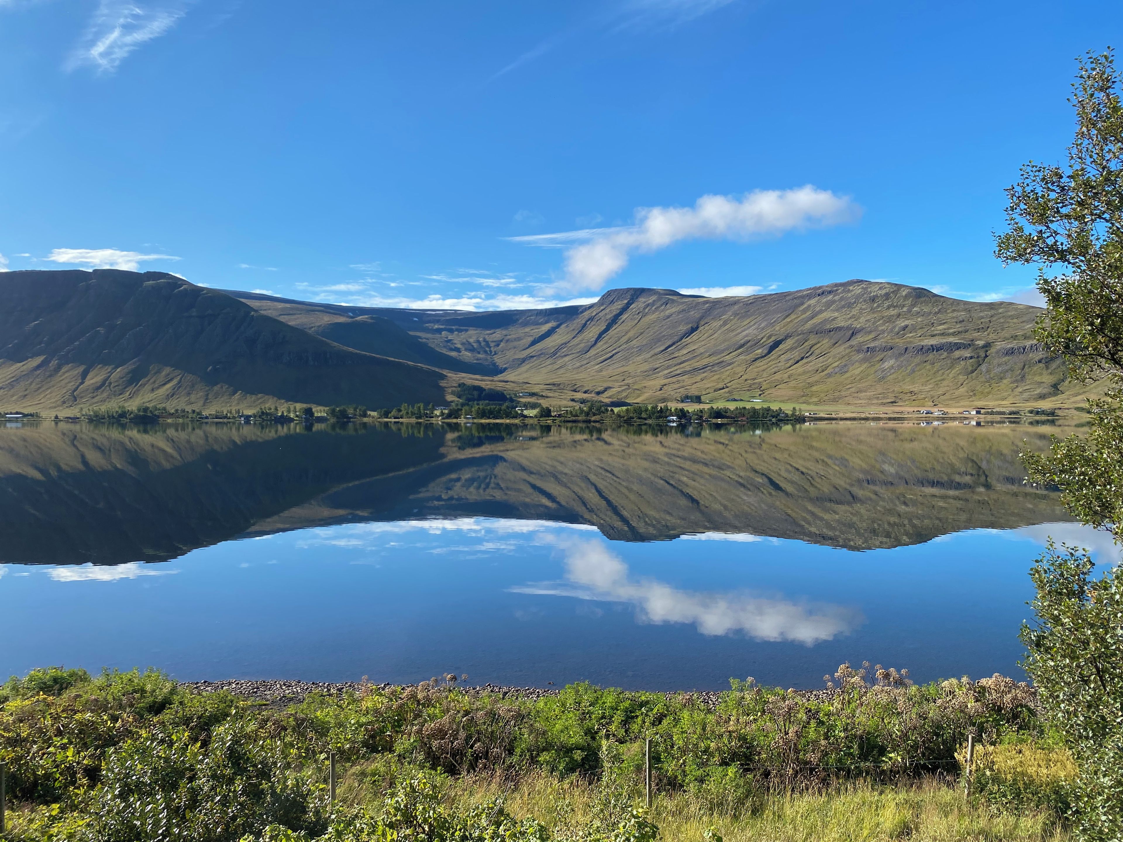 A tranquil lake with mountains in the background and a clear sky.
