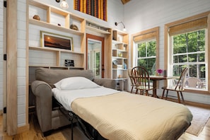 A compact room with a bed, a desk, and a chair.