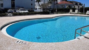A swimming pool with a 6 ft depth warning, surrounded by a paved deck, with a building in the background. - 30A Style! Private Beach | Chair Service Included (Seagrove)