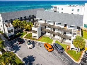 A multi-story building with a parking area and a view of the ocean. - New 30A Style! Private Beach | 5 Star Host (Seagrove)
