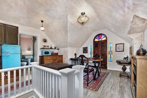 A kitchen with a blue refrigerator, wooden cabinets, and a dining area with a table and chairs.