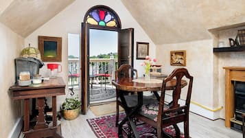 Un comedor acogedor con una mesa redonda, sillas y una ventana con vitrales.