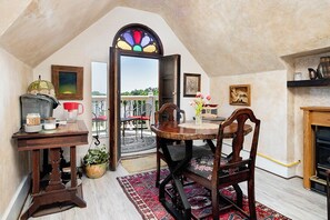 Un comedor acogedor con una mesa redonda, sillas y una ventana con vitrales.
