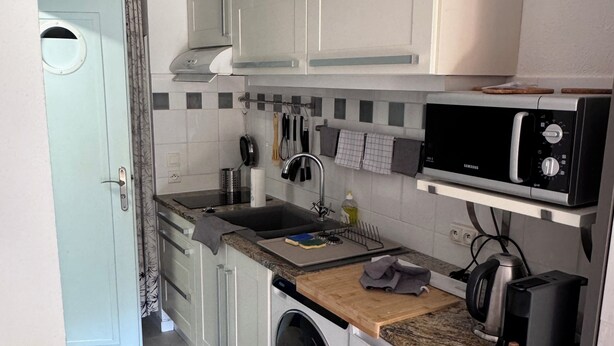 A compact kitchen with a washing machine, microwave, and a sink. - PLAGE St CLAIR APARTMENT Le Lavandou Saint Clair, for two on St. Clair Beach (Le Lavandou)