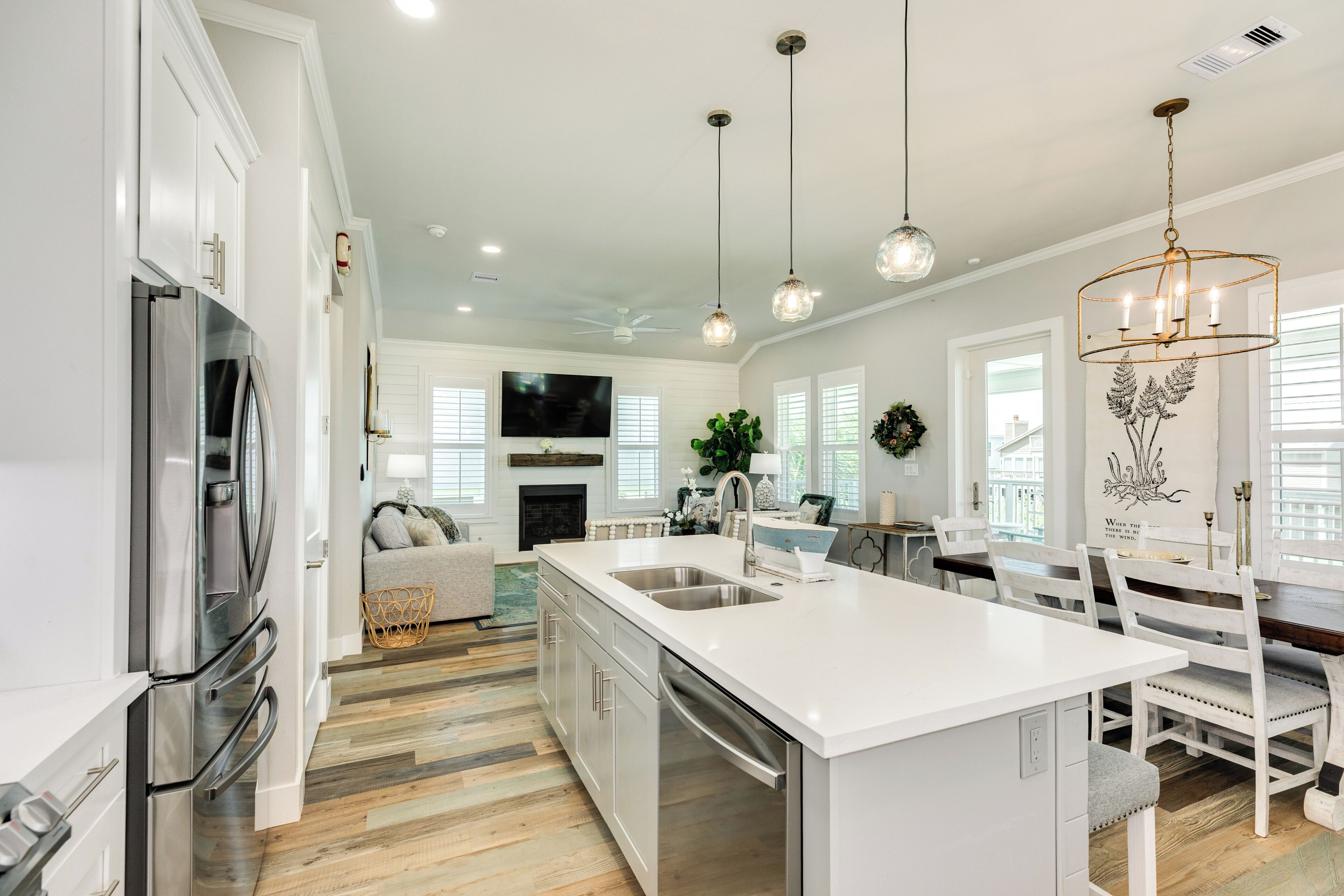 A spacious kitchen with a central island, stainless steel appliances, and pendant lighting.