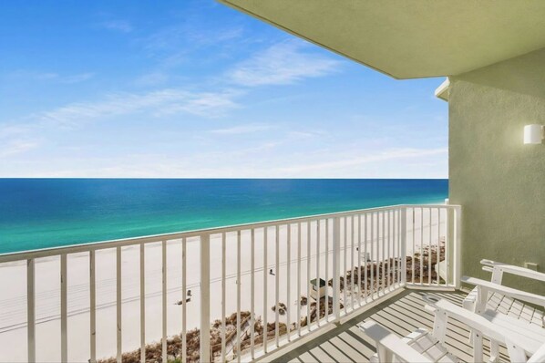 A balcony with a view of the beach and ocean.