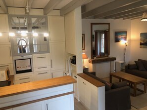 Ein kompakter Wohnbereich mit Küchenzeile, Essbereich und einer Sitzecke mit Sofa und Tisch.