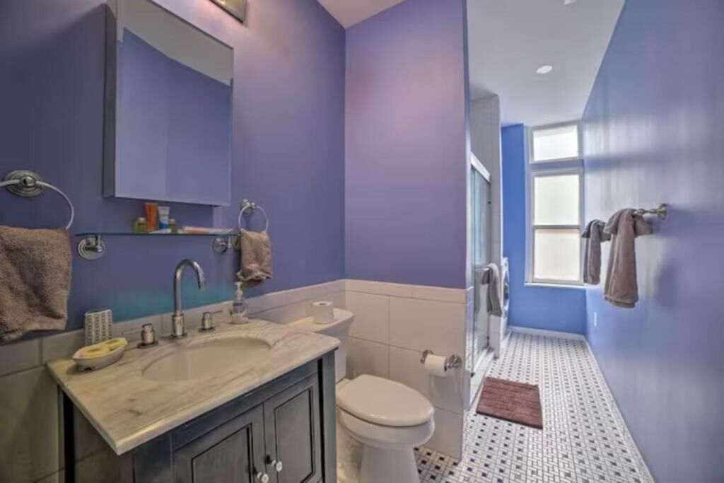 Een badkamer met een wastafel, spiegel en toilet.