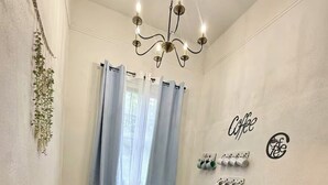 A small, cozy room with a wooden bench, a table with a coffee maker, and a wall-mounted coffee station.