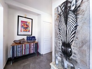 A hallway with a colorful striped cabinet, a framed abstract painting, and a large zebra mural. - Villa Panorama Marin · Bois Jolan · 5 BR · 426969 (Sainte-Anne)